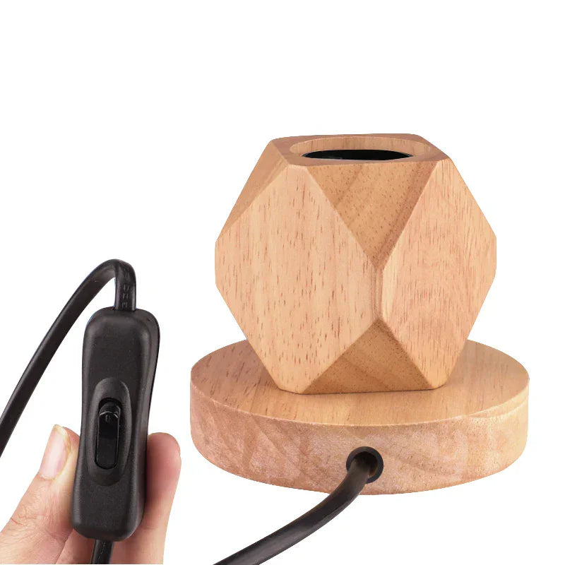 Wooden geometric lamp with a hand holding a black control cable 