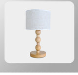 Table lamp with wooden base and white lampshade on a light gray background
