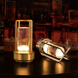 Two gold lanterns on a wooden surface with a warm glow